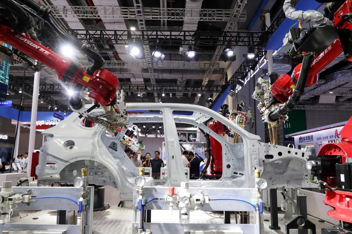 Visitors watch a robot perform welding on the body of a car at the China International Industry Fair in Shanghai on September 19. Photo: Xinhua