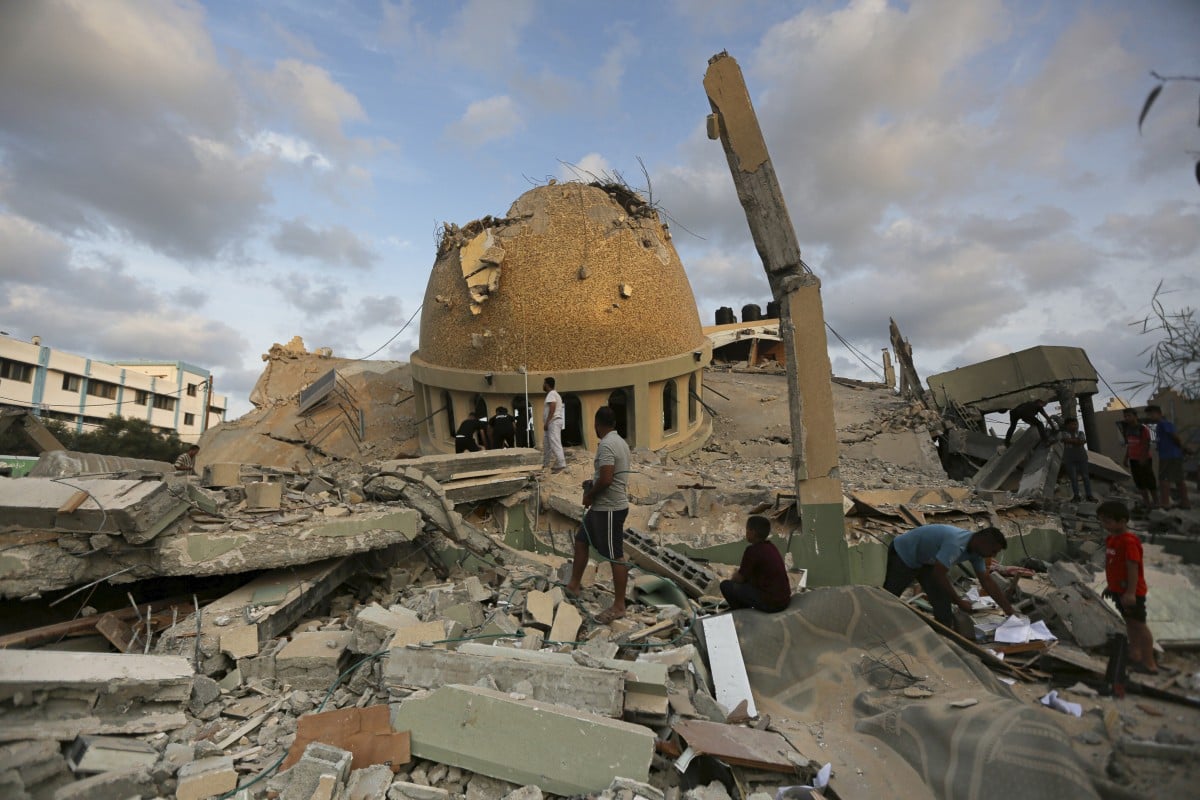 People stand outside a mosque destroyed by an Israeli air strike in Khan Younis, Gaza Strip, on October 8. Photo: AP